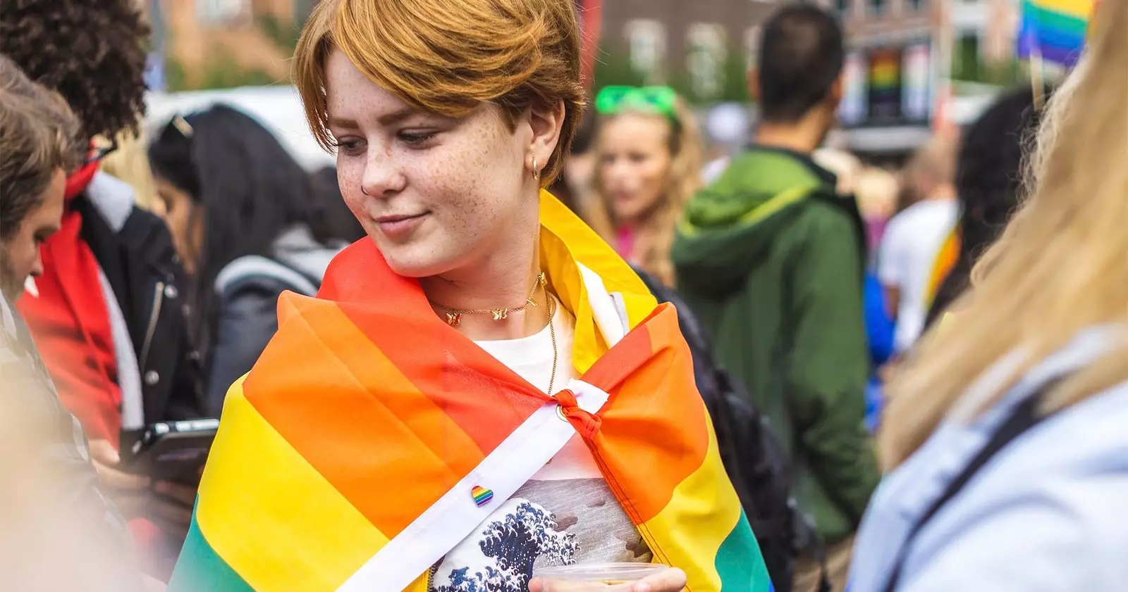 rödhårig tjej firar gay pride med flagga