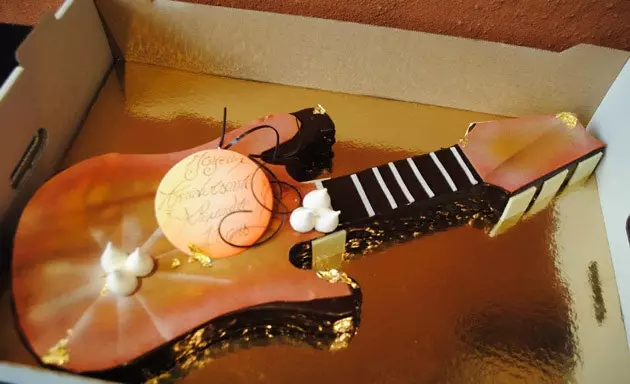 Bolo de aniversário em forma de guitarra elétrica.