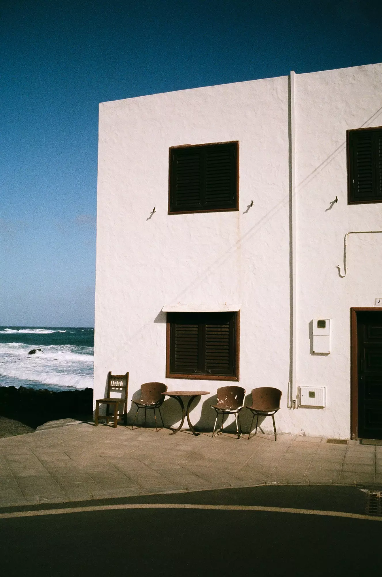 Stoelen in de zon voor een huis in Arrieta, een pittoresk kustplaatsje met nog geen duizend inwoners