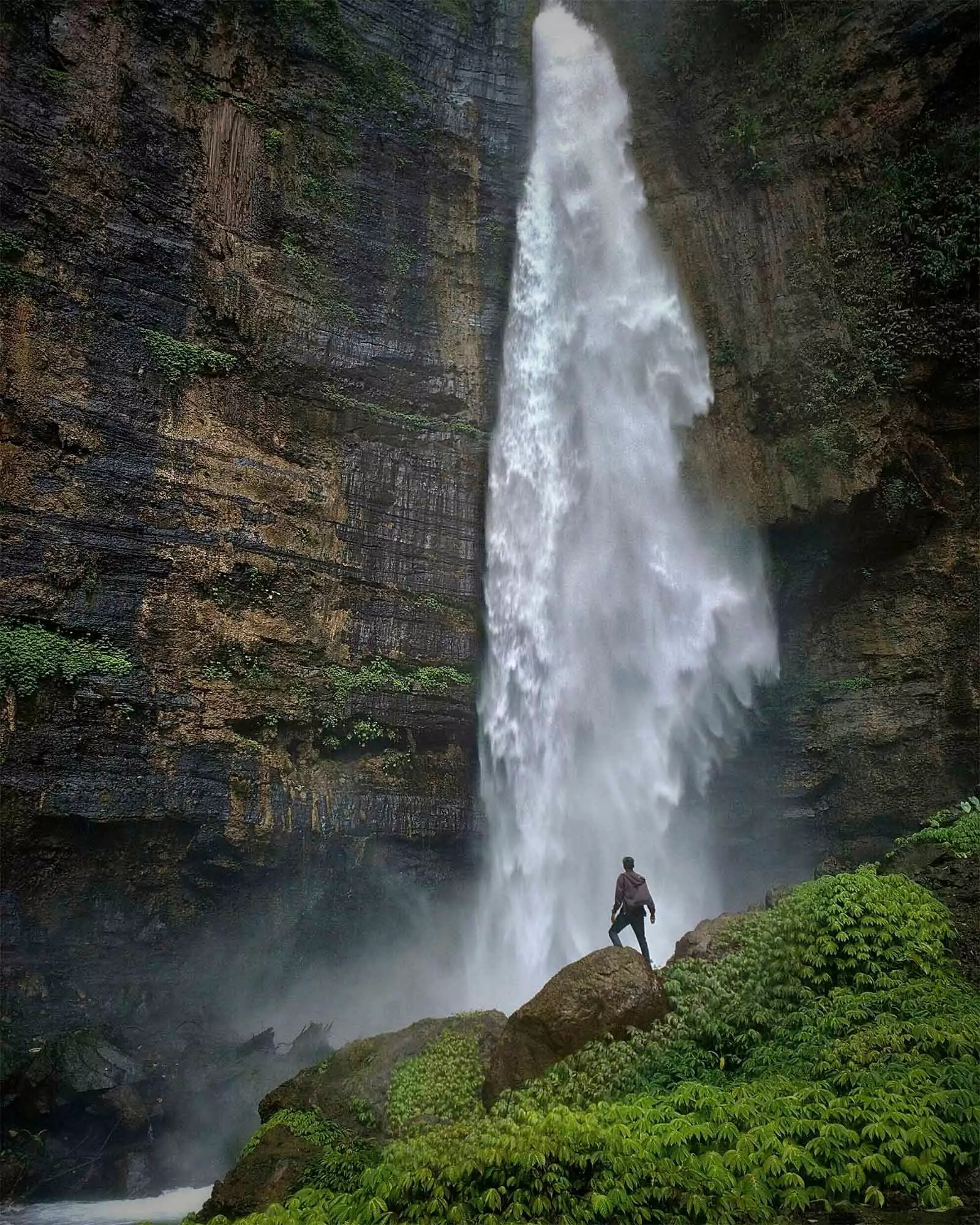 menino em frente a cachoeira