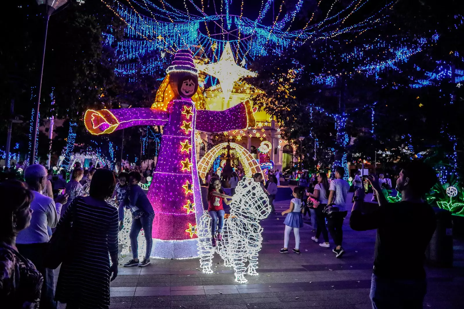 Jente som tar bilder i julebelysningen i Medellín