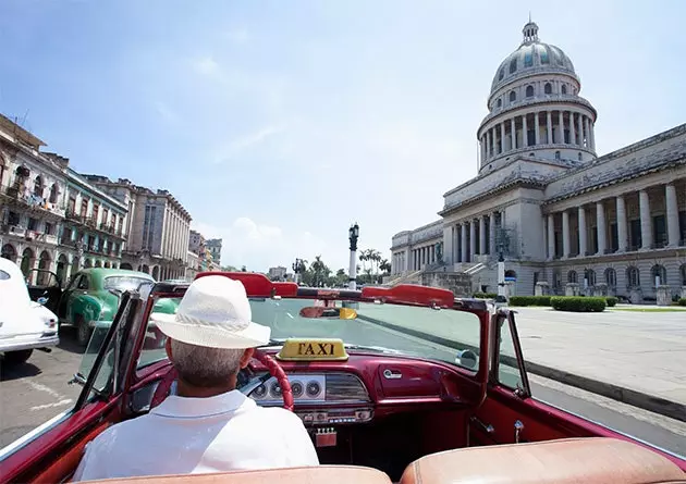 Een Cubaanse taxi grenst aan El Capitolio gebouwd in 1929