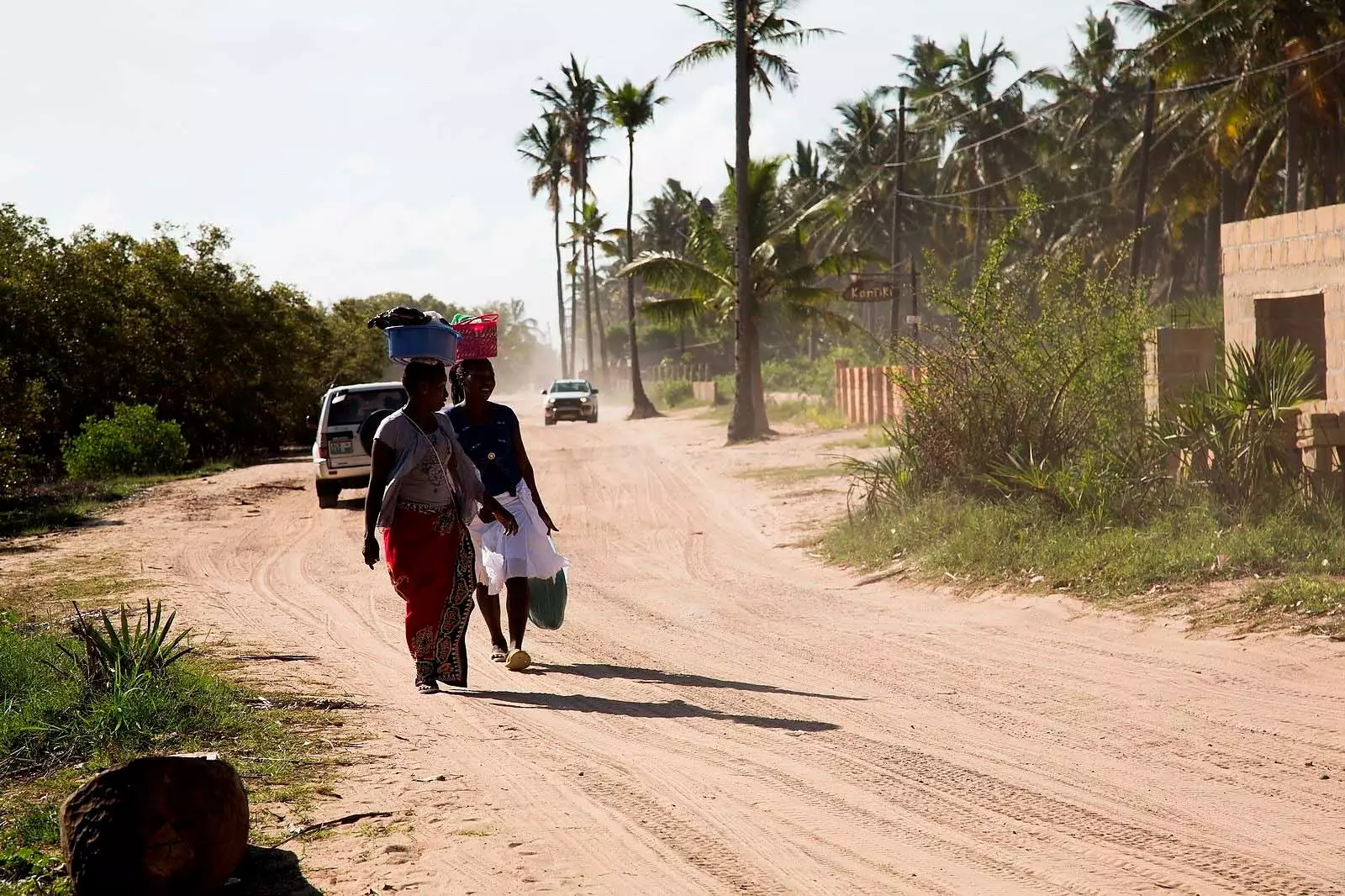 dvě africké ženy chodí se zavazadly na hlavě