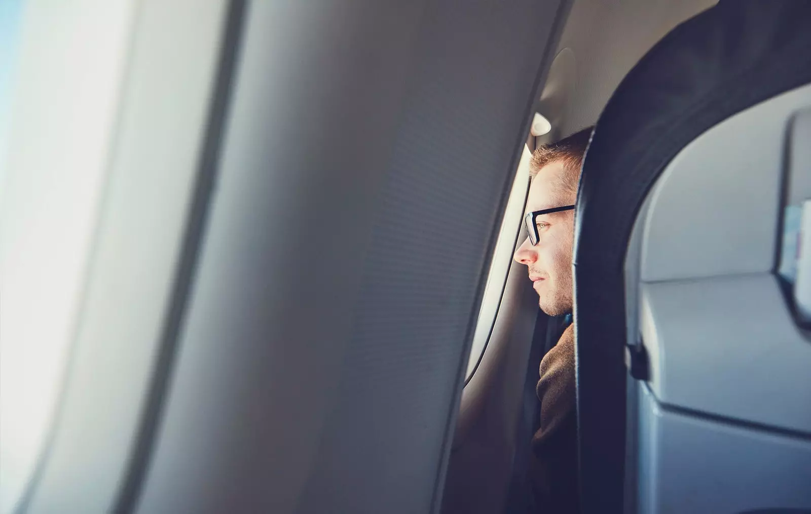 homme regardant par la fenêtre de l'avion