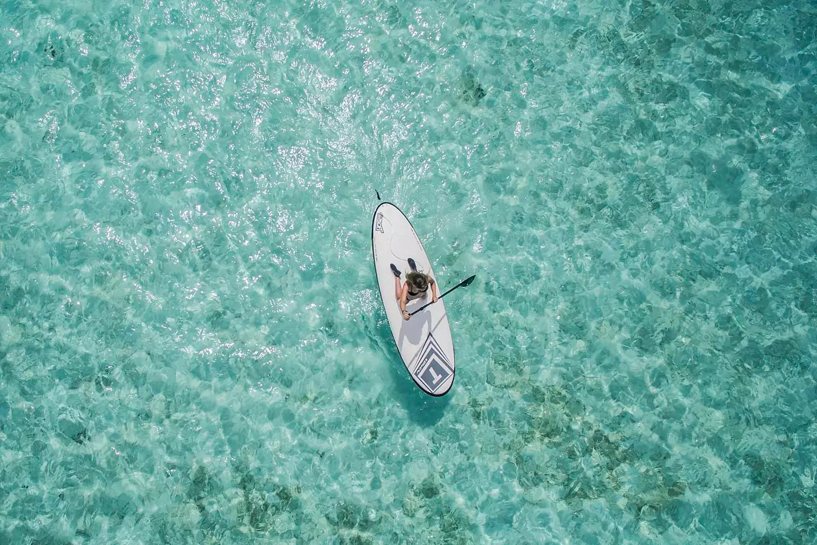 aerial shot of girl paddleboarding