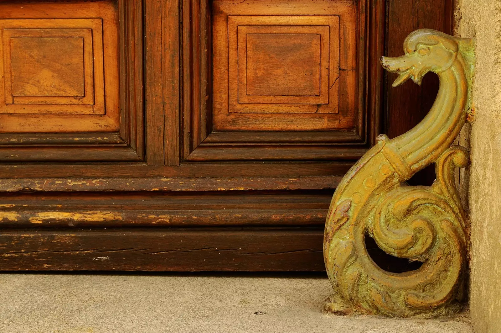 Detail van een drakenfiguur op een houten deur in de Viriato-straat.