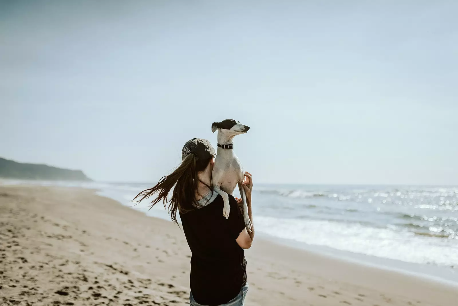 Kvinne med hunden sin på stranden