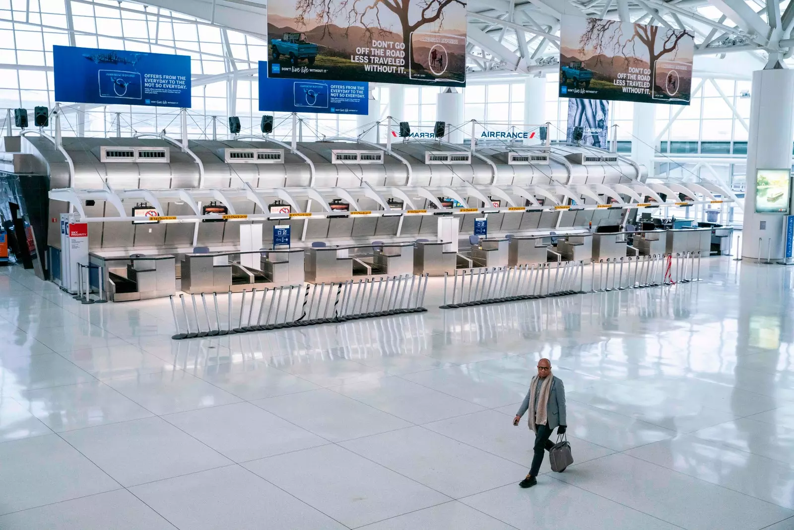 A person walks past several check-in counters at New York's John F. Kennedy International Airport