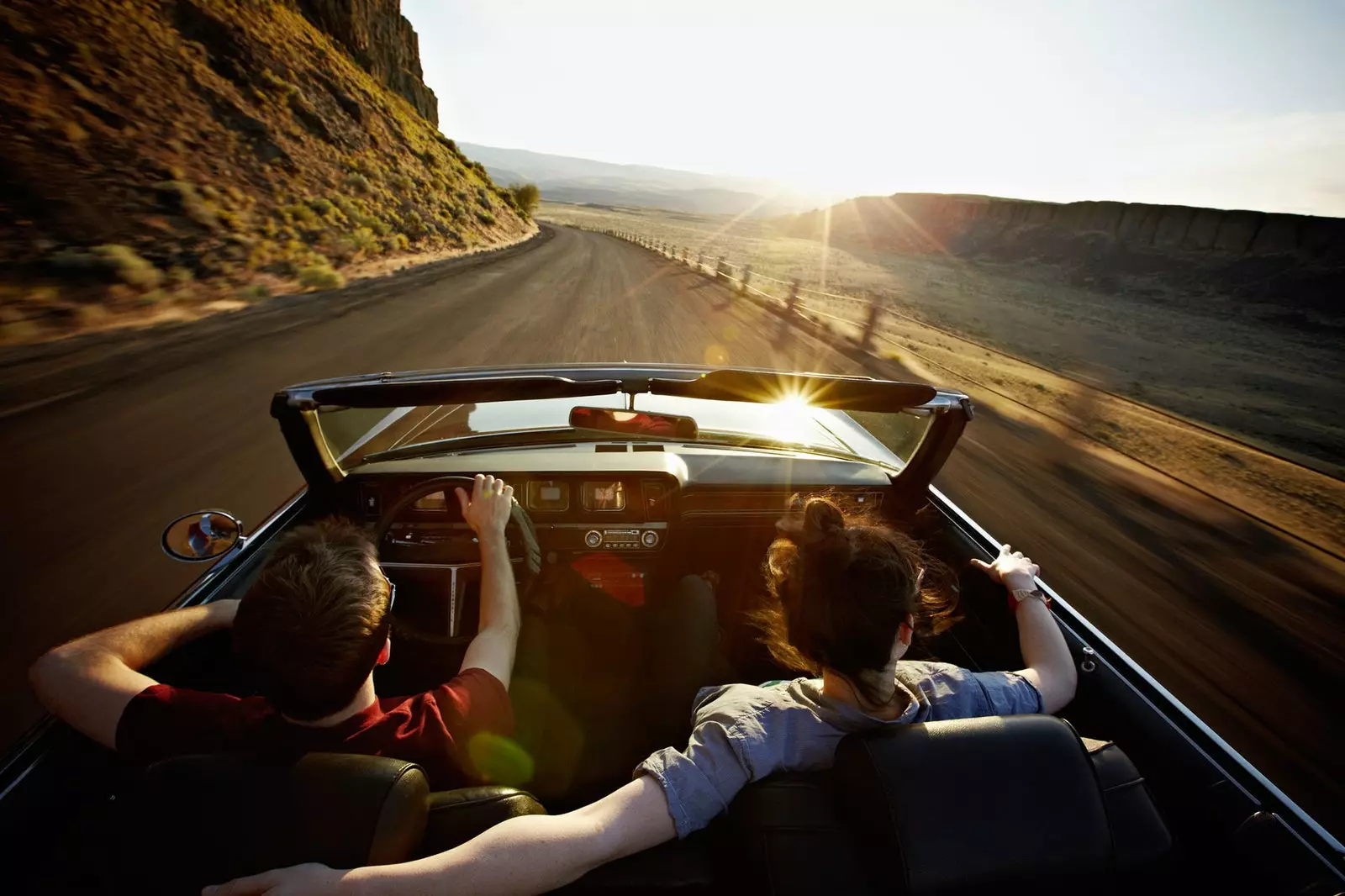 Couple doing a road trip in a convertible along the coast