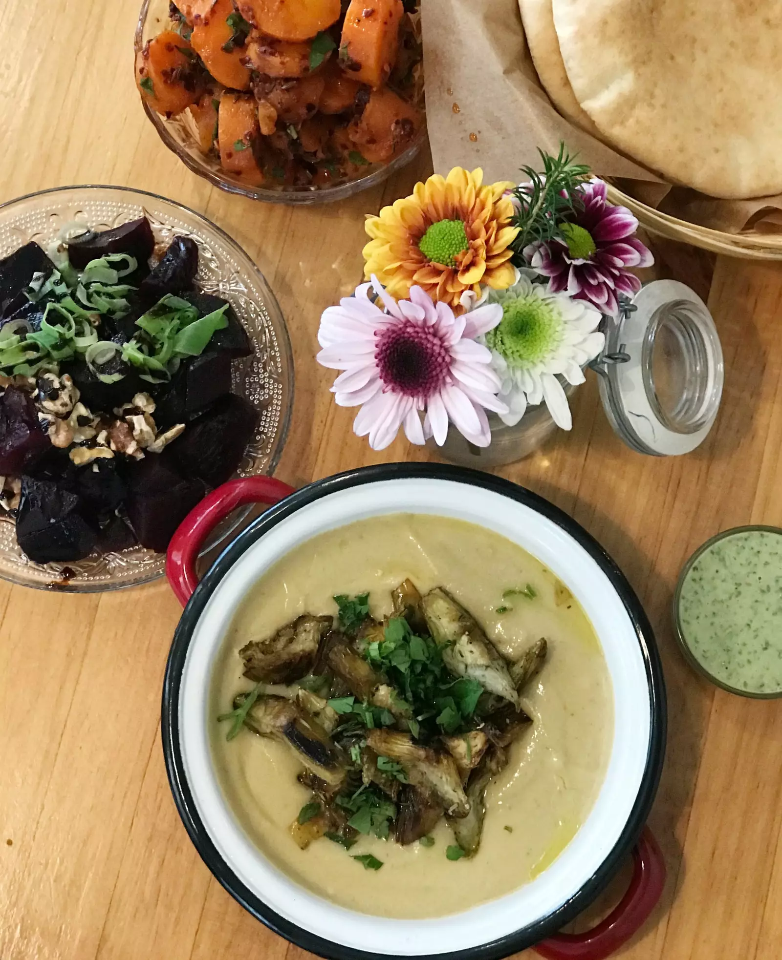 Hummus con carciofi al limone accompagnato da tapas fresche e pane pita all'Hummuseria.