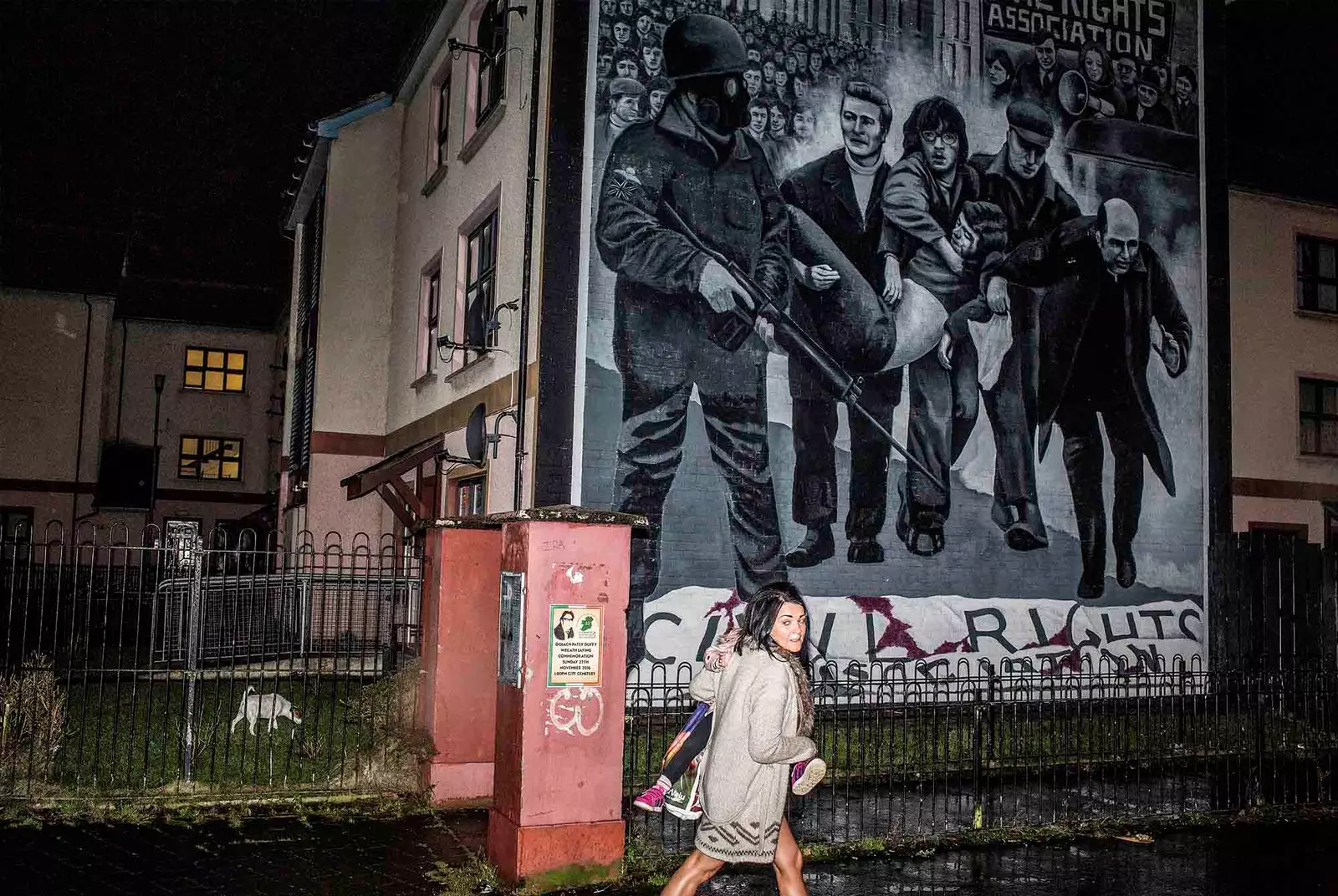 emberek sétálnak el egy falfestmény mellett Belfastban