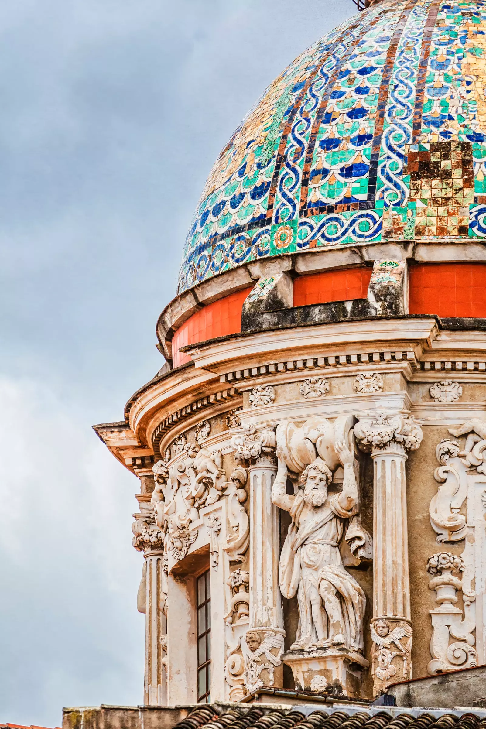 Baroque style church dome adorned with tiles in green blue yellow and reddish tones