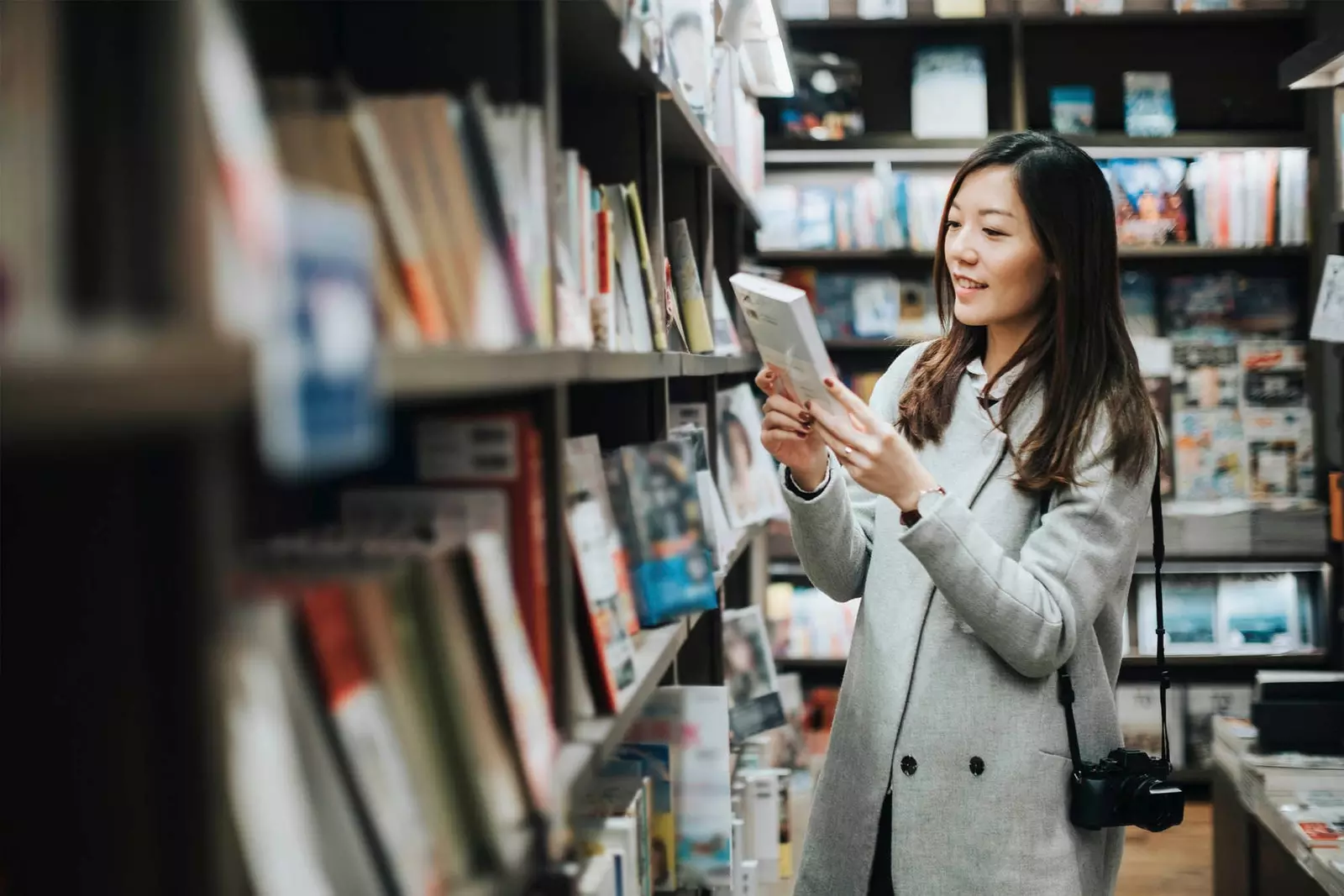 mulher asiática, tirando um livro da prateleira