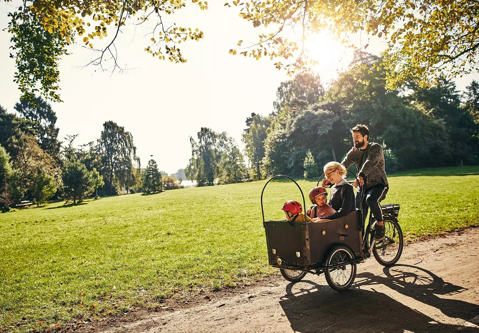 Een vader rijdt met zijn kinderen op een fiets in Denemarken