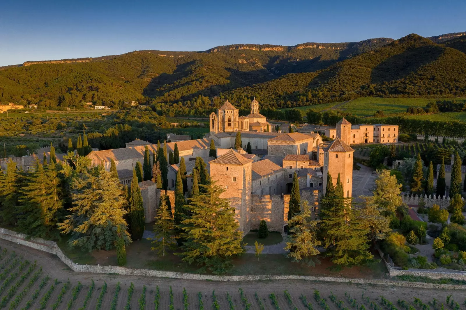 Mainistir Ríoga Santa María de Poblet ag luí na gréine.